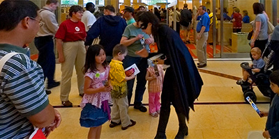 Batgirl hands out bookmarks at the grand opening of the new Minneapolis Public Library.